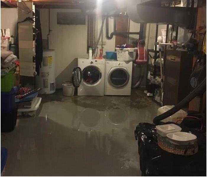 flooded basement with concrete flooring covered in water