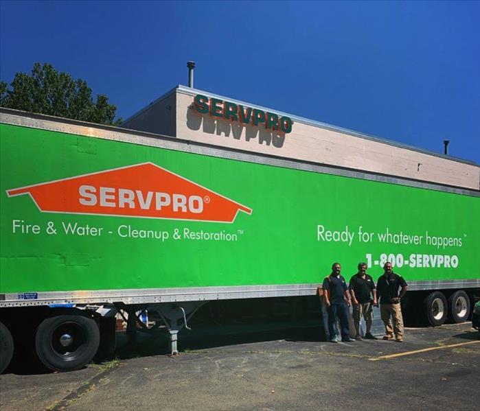 employees standing outside of green servpro truck